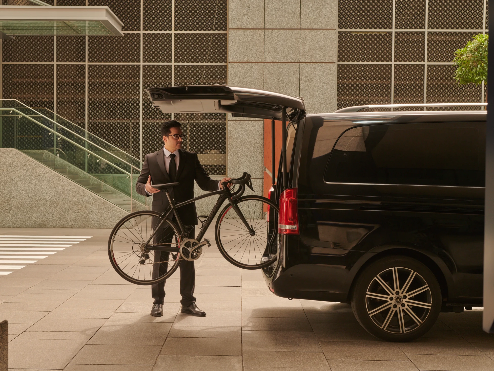 Chauffeur laadt een fiets in het busje voor een privétransfer