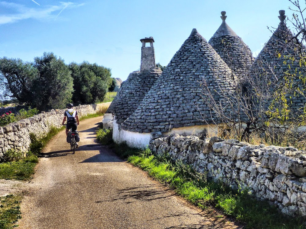 Fietser bij een traditionele trullo in de Valle d'Itria, Puglia