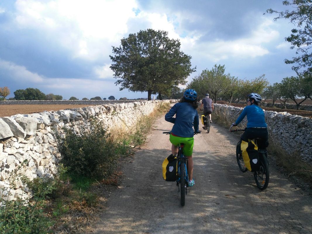 Fietser bij een traditionele trullo in de Valle d'Itria, Puglia
