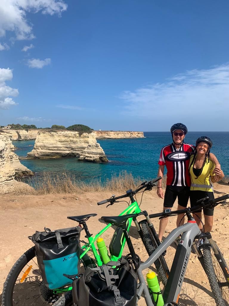 Twee fietsers met huur-e-bikes aan de rotskust van Puglia